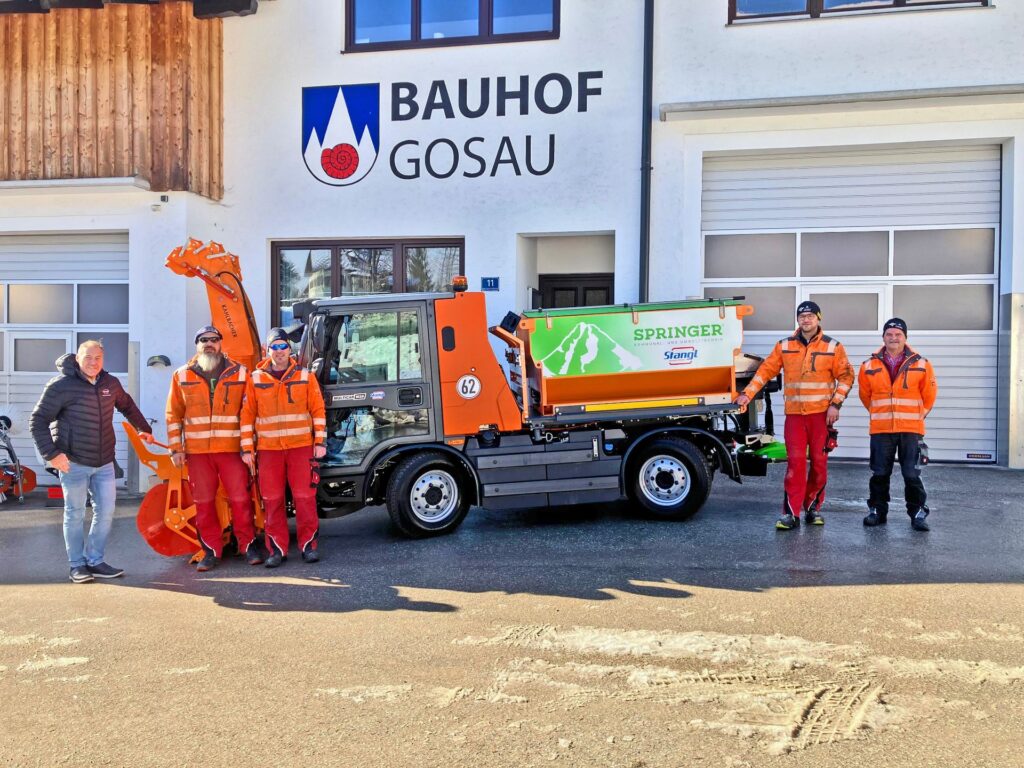 Übergabe des Multicar M29 mit Springer-Streuautomat beim Bauhof Gosau an Mitarbeiter in Warnschutzkleidung.
