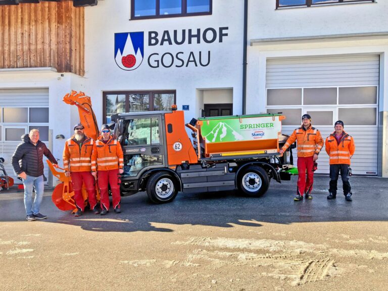 Übergabe des Multicar M29 mit Springer-Streuautomat beim Bauhof Gosau an Mitarbeiter in Warnschutzkleidung.
