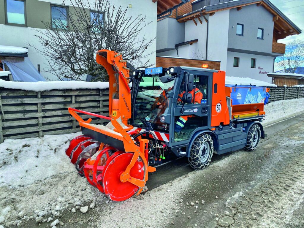 Stangl Multicar M29 Kommunalfahrzeug mit Kahlbacher Schneefräse im Winterdienst auf einer verschneiten Straße.