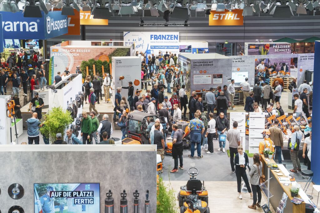 Gut besuchte Fachmesse mit Ständen von Stihl, Husqvarna und Franzen sowie zahlreichen Besuchern in einer Messehalle.