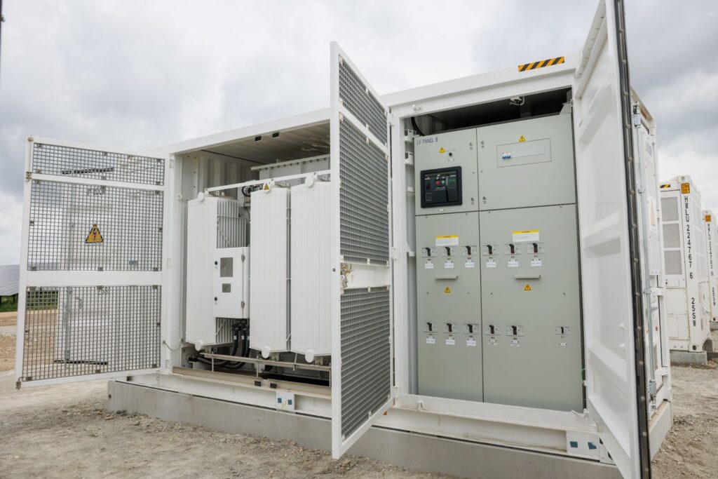 PÜSPÖK realisiert Super-Hybrid-Park in Nickelsdorf 3 Geöffneter Technikcontainer mit einem Transformator und elektrischen Schaltschränken zur Energieverteilung im Außenbereich.