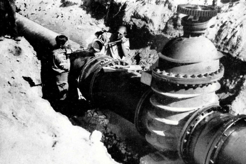 Rohstoff statt Reststoff: Graz setzt auf Kreislaufwirtschaft bei Gussrohren 1 Historische Bauarbeiten an einer massiven Wassertransportleitung mit Arbeitern in einem Graben der Holding Graz.