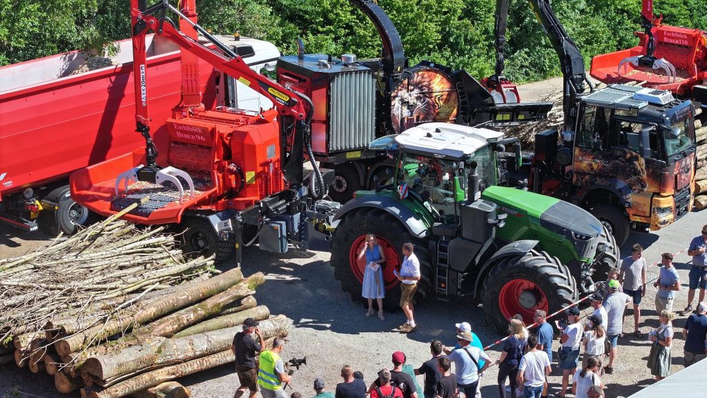 Eschlböck Biber 96 Holzhacker mit Palfinger Kran und grüner Fendt Traktor vor Publikum bei einer Forsttechnik-Vorführung.